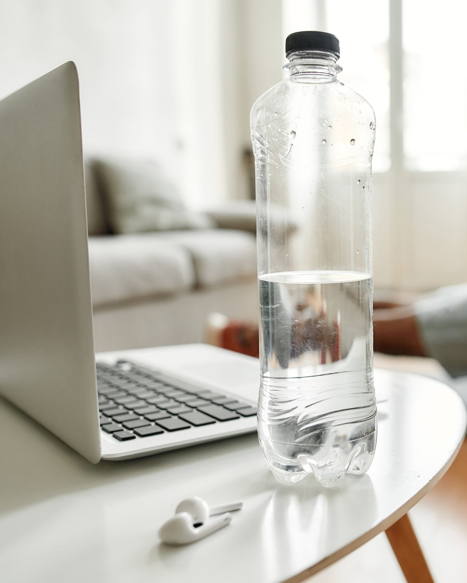 Home workout with water bottle, laptop and AirPods
