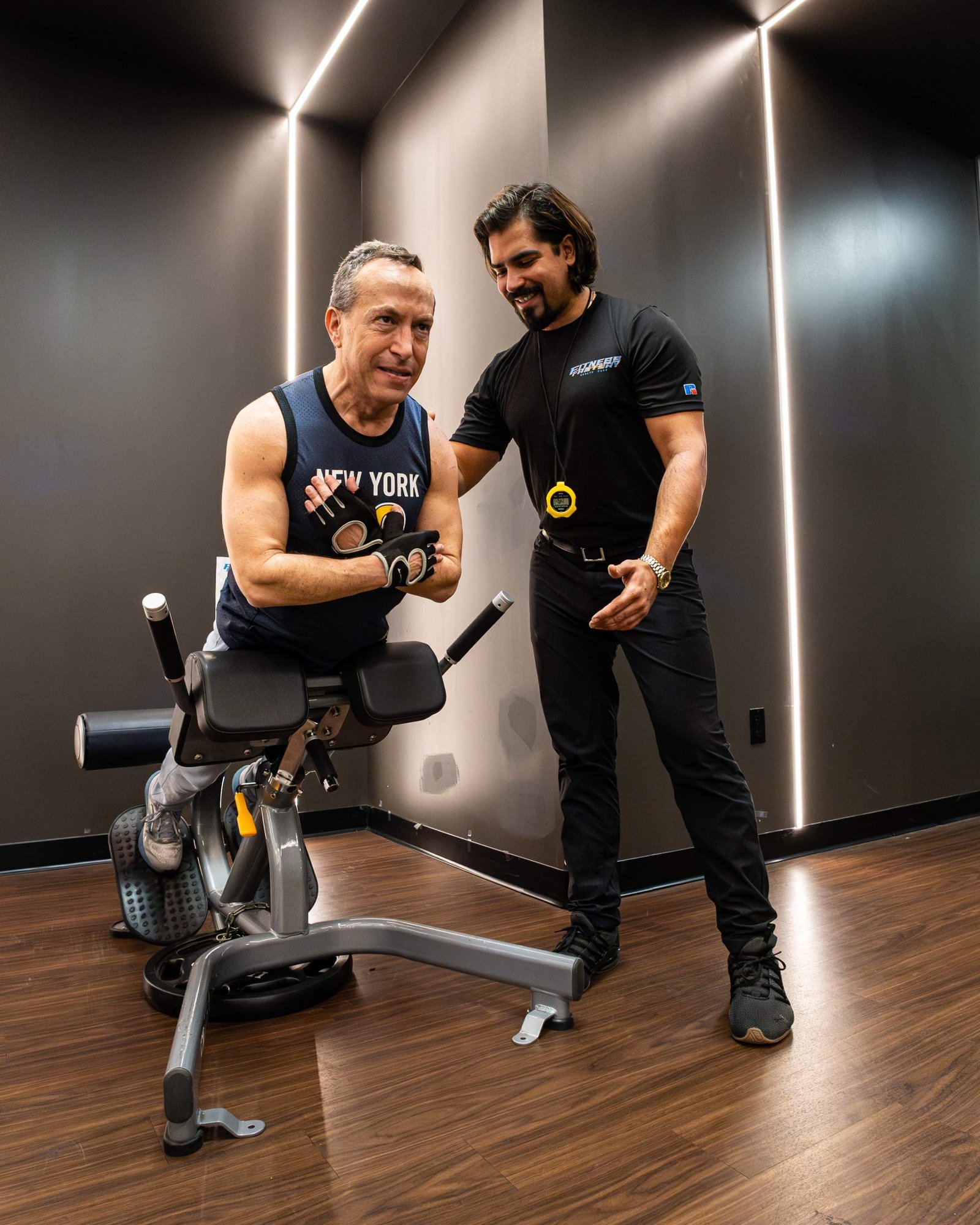 Personal trainer training a man with weights at the gym